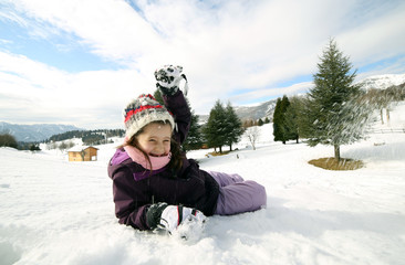 Fototapeta na wymiar young girl play with snow in the mountains in winter