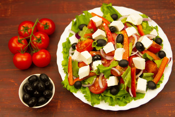 cooking summer Greek salad on wooden background