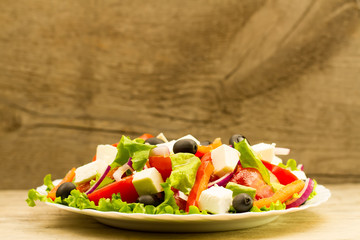 cooking summer Greek salad on wooden background
