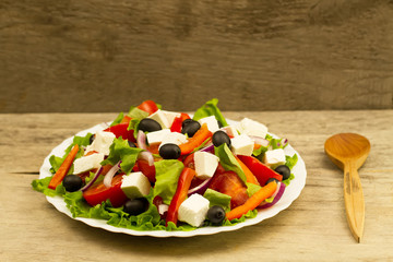 cooking summer Greek salad on wooden background