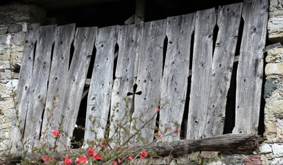 gate of an old barn with the symbol of the cross