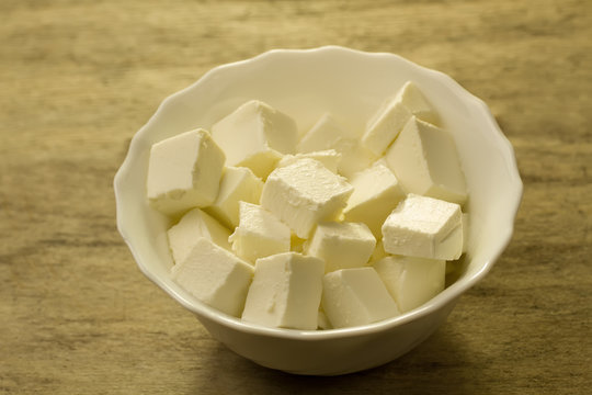 Feta is a traditional Greek cheese on wooden background