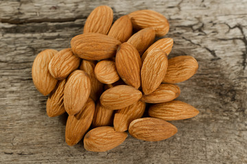 peeled almonds on wooden background. For vegetarians