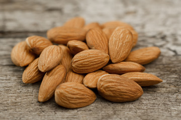 peeled almonds on wooden background. For vegetarians