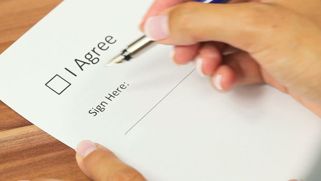 Female hand checking the "I agree" checkbox and applying a signature on the line below