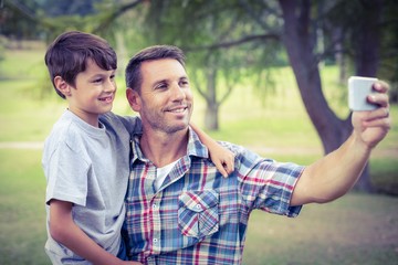 Father and son taking a selfie in the park