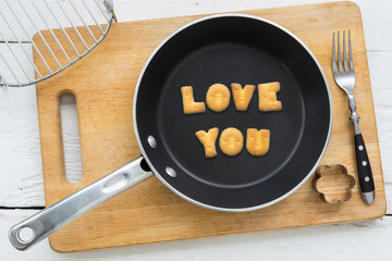 Letter cookies word LOVE YOU and kitchen utensils