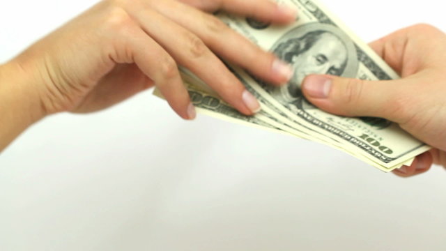 Male hand with cash teasing female. Several one hundred dollar bills are being passed from one hand to the other. For concepts like payments, corruption, divorce, sugardaddies etc