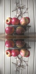 Äpfel in einer Schale dahinter ein Bonsai