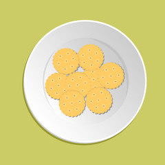 Cracker cookies isolated on green background. Round, dry cookies in a white plate.