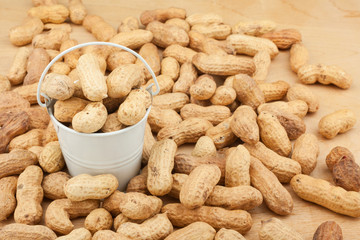 White bucket with  dried peanuts  on the wooden floor