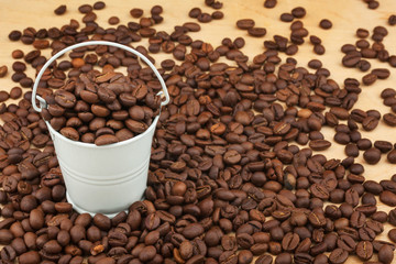 White bucket with coffee beans  on the wooden floor