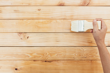 hand painting brush clear lacquer on wood surface