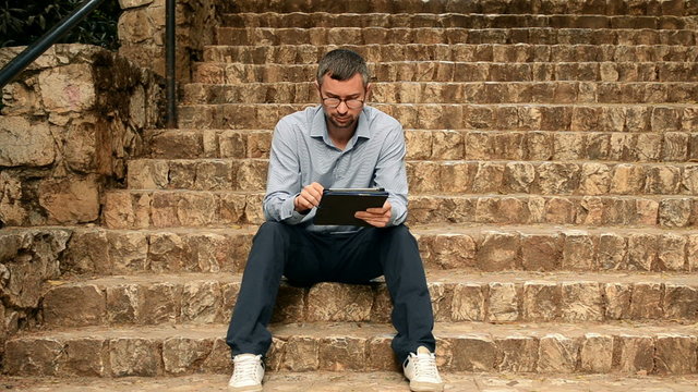 Student using on tablet on the stairs