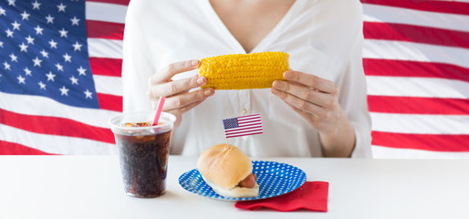 woman hands holding corn with hot dog and cola