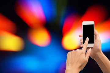 Hand using smart phone with abstract motion light background.