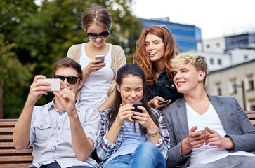 students or teenagers with smartphones at campus
