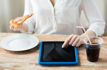 close up of woman with tablet pc having dinner