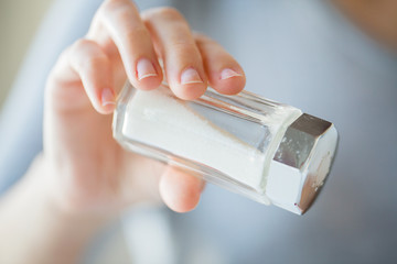 close up of hand holding white salt cellar