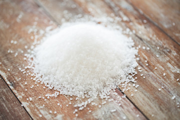 Fototapeta na wymiar close up of white salt heap on wooden table