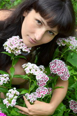 Fototapeta premium Девушка брюнетка с букетом турецких гвоздик