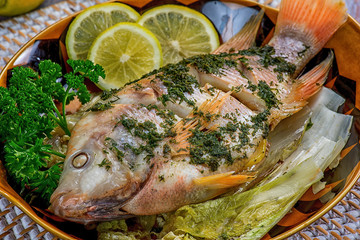 Fisch auf Gemüsebeet mit Kräutern