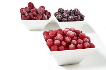 Drei Schalen mit verschiedenen gefrorenen Beerenfrüchten