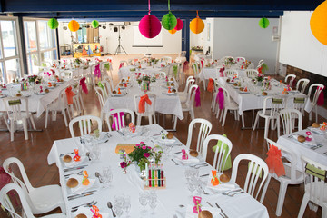 Table setting for an wedding reception in orange, pink and yellow color