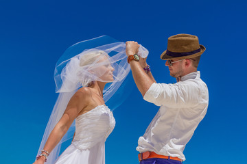 bride and groom enjoying beach wedding in tropics, on wedding ar