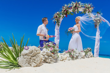 bride and groom enjoying beach wedding in tropics, on wedding ar