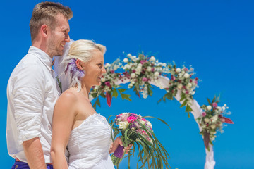 bride and groom enjoying beach wedding in tropics, on wedding ar