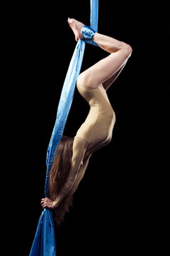 Flexible girl doing exercise on aerial tissues