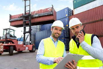 Dock worker and supervisor checking containers data