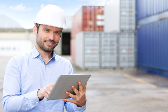Young Attractive engineer using tablet on the dock
