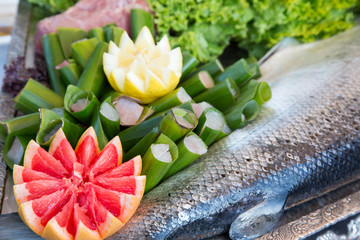 Pesce crudo avvolto in foglie di banano con pompelmo rosa e limone
