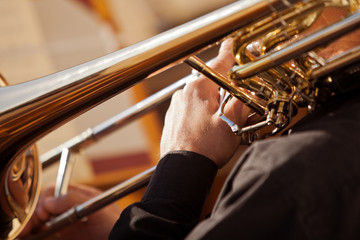 Fototapeta premium Fragment of the trombone in the hands of the musician