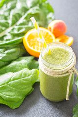 Blended green smoothie with ingredients 
