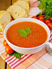 Soup tomato with bread on napkin and board