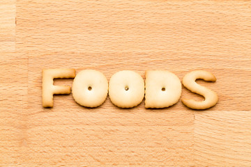 Word foods biscuit over the wooden background