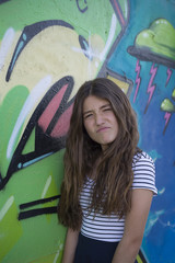 Girl posing next to a graffiti