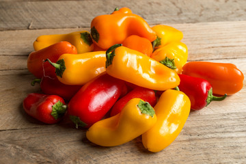 Colored bell peppers on a weathered wood background.