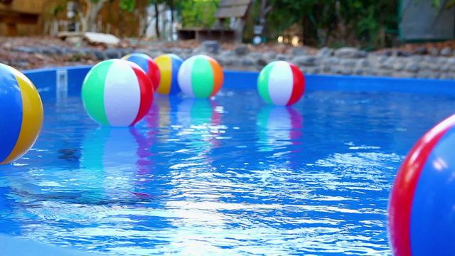Colorful beach balls floating in pool.