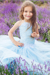 Happy little girl in a field of lavender, summer