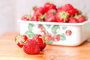 Strawberries in a metal bowl on the table, next to the three bal