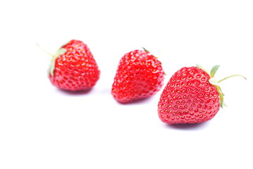 Three strawberries on a white background with shadow