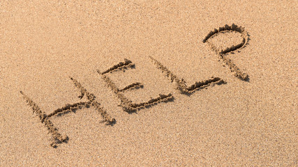 Help Sign Drawn On Beach Sand
