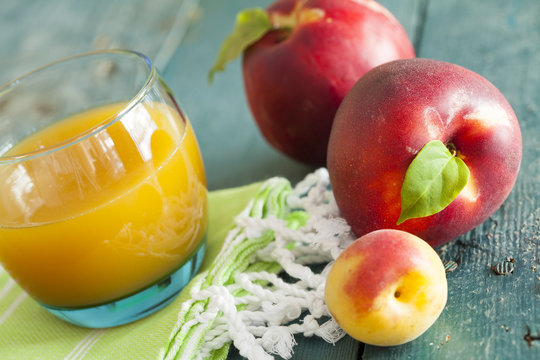 Group of fresh peaches and juice on vintage wooden