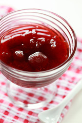 Homemade Strawberry jam in a glass vase on white background