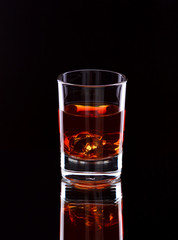 Glass of whiskey on dark background, selective focus