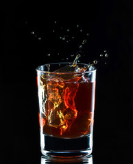 Glass of whiskey on dark background, selective focus